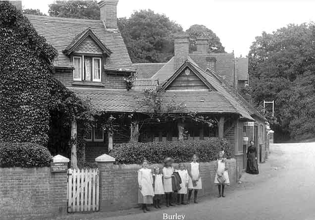 Burley - a group of young children pose for the camera outside the doctors' surgery, watched by an older lady outside the library. (Early years of the 20th century).